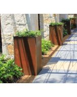 Four weathered Cor-Ten steel planters evenly spaced along a stone driveway.