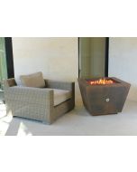 Weathered Cor-Ten steel pyramid fire pit with red fire glass in fire bowl with flames in fire bowl.  On off key valve is in the middle of the side of the fire pit.